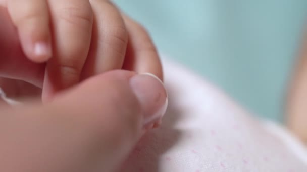 Madre sosteniendo suavemente la mano del bebé recién nacido de cerca, paternidad dulce, maternidad — Vídeo de stock