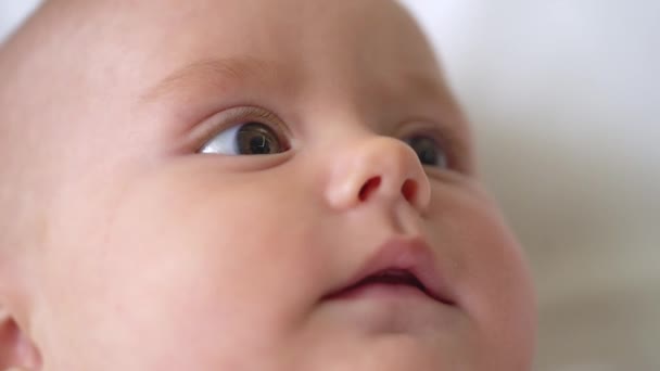 Sömnig baby ansikte närbild, söt spädbarn tittar på leksak, känna sig trygg och glad — Stockvideo