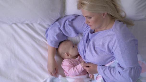 Молодая мать кормит грудного ребенка грудным молоком, естественным материнством, здравоохранением — стоковое видео