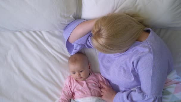 Sevimli bebek annesiyle dinleniyor, bebek güvenliği için yatak paylaşıyor. — Stok video