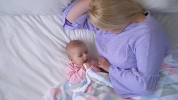 Szczęśliwa kobieta delikatnie dotyka twarzy dziecka, uśmiechając się czule i ciesząc się macierzyństwem — Wideo stockowe