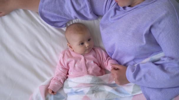 Dulce bebé acostado en la cama cerca de la madre, sintiéndose seguro y cómodo, co-durmiendo — Vídeos de Stock