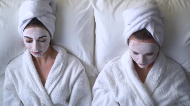 Filles heureuses se détendre dans le spa avec masque nettoyant pour le visage, procédures de soins de la peau — Video