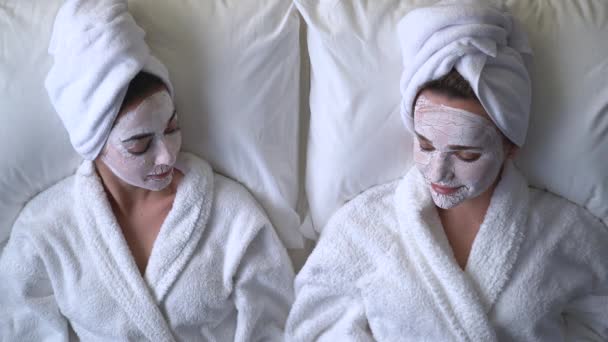 Deux belles amies parlent tout en profitant des procédures de soins de la peau au spa — Video