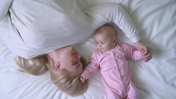 Top kilátás boldog anya és szép baba feküdt az ágyban, anyaság boldogság — Stock videók