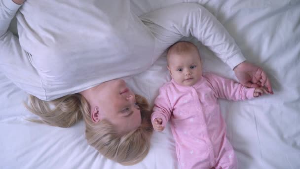 Doce menina e mamãe deitada na cama, momentos ternos, felicidade maternidade — Vídeo de Stock