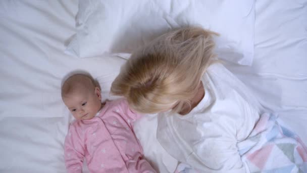 Anne bebek ayaklarına dikkatlice dokunuyor, küçük kızına şefkatle bakıyor. — Stok video