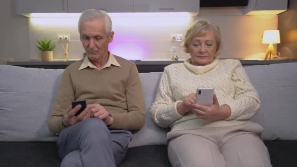 Σύγχρονη ηλικιωμένους άνδρες και γυναίκες κύλιση τηλέφωνο app, κάθεται στον καναπέ, internet — Αρχείο Βίντεο