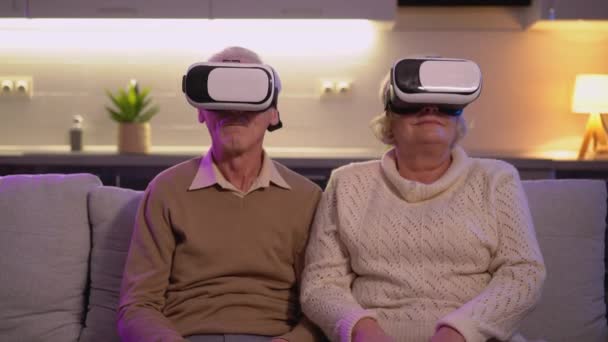 Pareja jubilada con gafas vr, impactada o asustada, simulación de realidad virtual — Vídeo de stock