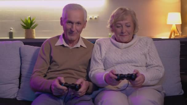 Entusiasmado casal sênior jogando videogame juntos, pressionando botões joystick — Vídeo de Stock