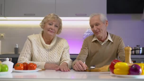 Cuidar anciano hombre suavemente tomando esposa a mano, feliz pareja de ancianos sonriendo — Vídeo de stock