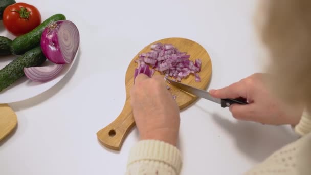 Woman chopping onion with sharp knife in kitchen, cooking hobby, healthy meal — 비디오