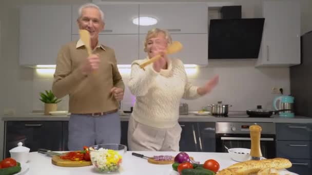 楽しさと冗談、良い気分を持って、キッチンで踊る面白い高齢者のカップル — ストック動画