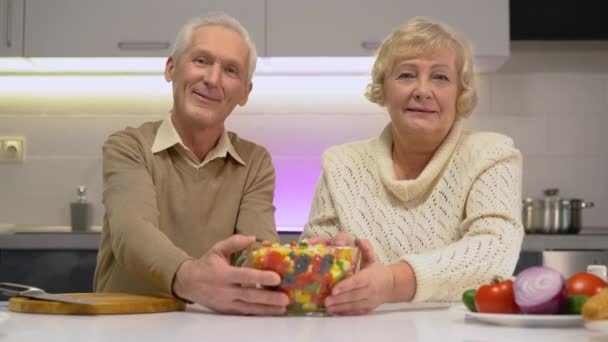 Elderly couple holding out bowl of fresh salad, healthy nutrition for long life — Stock Video