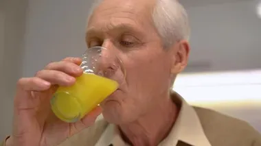Kıdemli adam kahvaltıda hafif salata ve sandviç yiyor, sağlıklı bir yaşam tarzı.