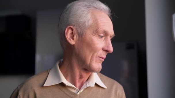 Sad thoughtful elderly man standing in room alone, concerned about retirement — Stock Video