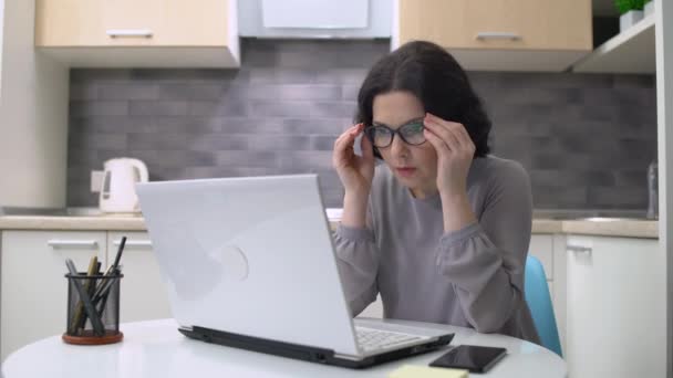 Message texte du patron féminin sur l'ordinateur portable, pensant à la solution de problème, travail à distance — Video