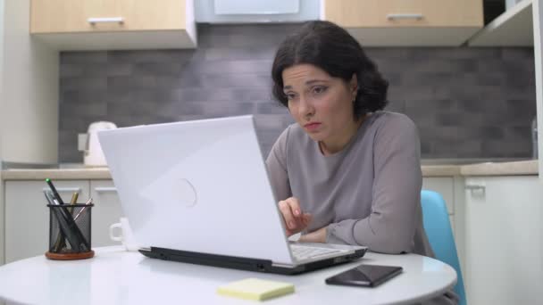 Нудна брюнетка леді працює на ноутбуці вдома, професійне вигорання, виснаження — стокове відео