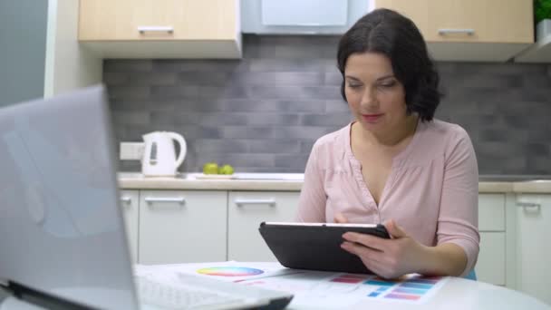 Középkorú szabadúszó dolgozik tabletta otthon, női tervező dolgozik online — Stock videók
