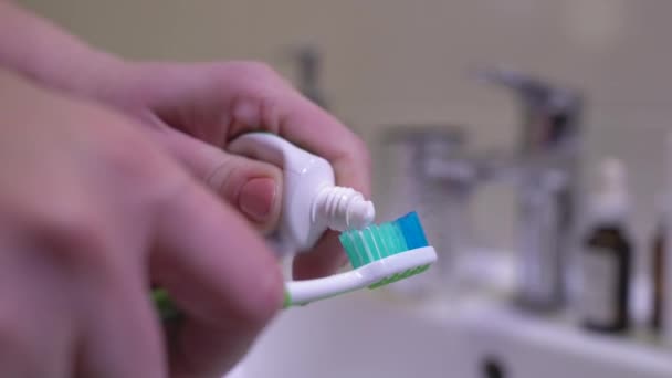 Persona que aprieta la pasta de dientes en el cepillo de dientes, cuidado dental diario para dientes sanos — Vídeo de stock