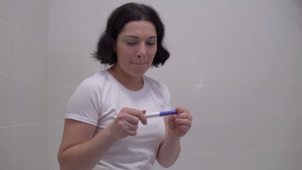 Donna speranzosa che controlla il test di gravidanza, piangendo delusa dal risultato negativo — Video Stock