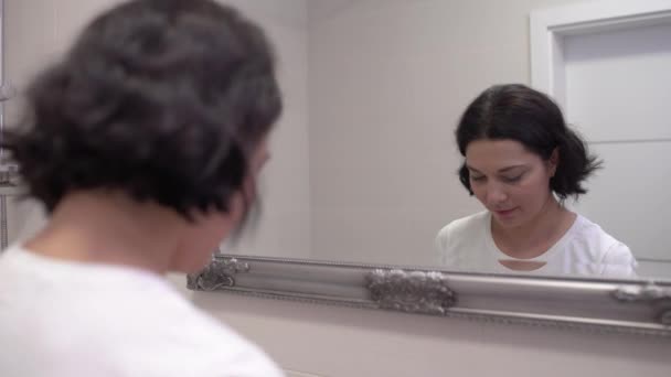 Jovem aplicando creme para os olhos para esconder círculos escuros de manhã, cuidados de beleza — Vídeo de Stock