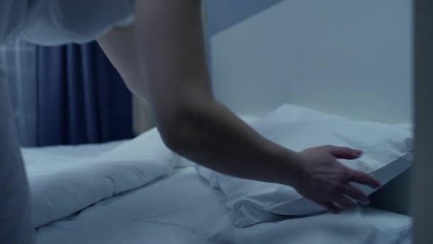 Втомлена жінка лежить в комфортному ліжку вночі, розслабляється після напруженого дня — стокове відео