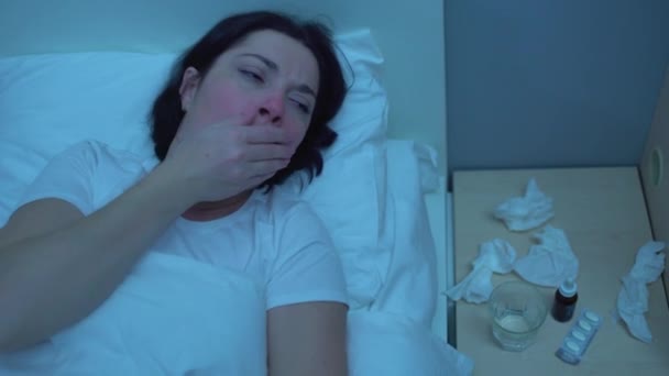 Hasta kadın geceleri yatakta öksürüyor, ilaçlar masada, akciğer hastalığı çekiyor. — Stok video