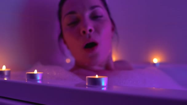 Mulher excitada relaxando no banho espumoso, soprando velas, noite romântica — Vídeo de Stock