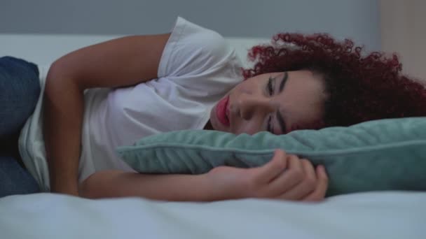 Young female feeling stomach pain, lying in bed, lonely teenager crying at home — Stock Video