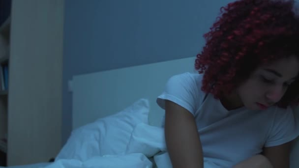 Mladá nemocná žena užívá pilulku s vodou, sedí v posteli pod přikrývkou, nemoc — Stock video
