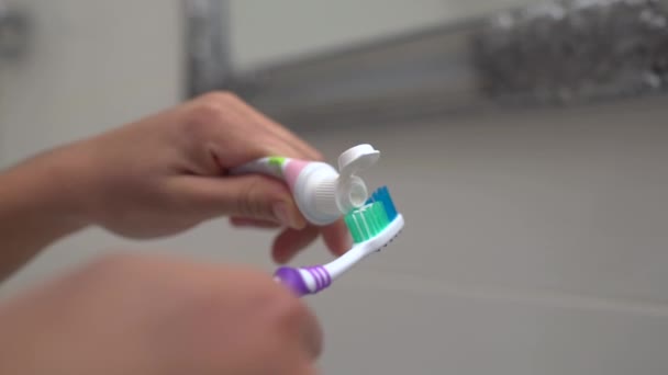 Vrouwelijke hand zetten tandpasta op tandenborstel, mondhygiëne, frisse adem, gezondheid — Stockvideo