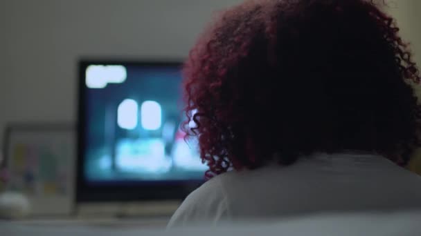 Африканский подросток наслаждается музыкой, смотрит кино по телевизору, современные технологии — стоковое видео
