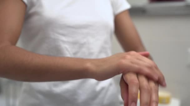 Woman in white t-shirt applying hand cream, moisturizing lotion, cosmetology — Stock Video