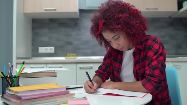 Estudiante inteligente escribiendo ensayo en cuaderno sonriendo, preparándose para las clases — Vídeos de Stock