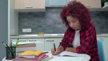 Not defterine yazan ciddi melez bir öğrenci, okul derslerine hazırlanıyor.