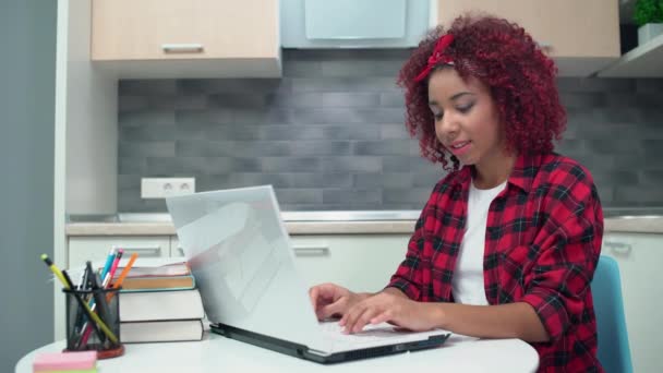 Όμορφη έφηβος κορίτσι πληκτρολογώντας στο φορητό υπολογιστή και χαμογελώντας, απολαμβάνοντας την επικοινωνία σε απευθείας σύνδεση — Αρχείο Βίντεο