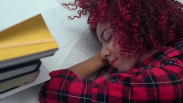 Студентка заснула на куче книг, выполняя домашнее задание, усталость — стоковое видео
