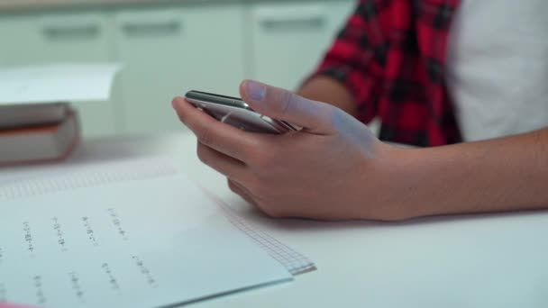 Dospívající student ruce rolování smartphone místo toho dělá domácí úkoly, odkládání — Stock video