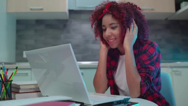 Chica feliz escuchando música, viendo clips en línea en el ordenador portátil, sonrisa en la cara — Vídeos de Stock