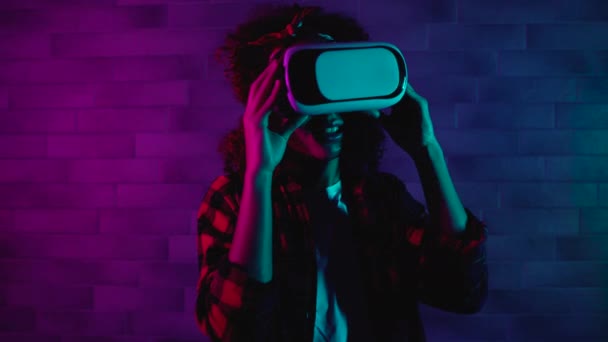 Nadšená mladá žena ve sluchátkách, rozhlížející se po světě virtuální reality — Stock video