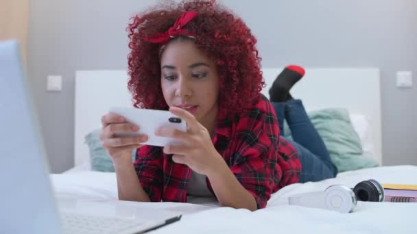 Adolescente afroamericana che gioca giochi per cellulare su smartphone, dipendenza gadget — Video Stock