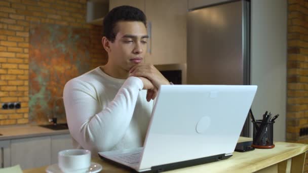 Hombre de raza mixta inspirado teniendo idea, escribiendo en el portátil en casa, blogger masculino — Vídeos de Stock