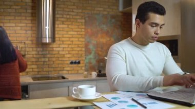 Yönetici dizüstü bilgisayarda yazıyor, mali rapor hazırlıyor, iş planı üzerinde çalışıyor.