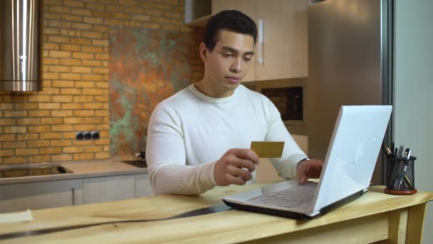 Succesvolle gemengde ras mannelijke typen gouden kaart nummer op laptop, online banking app — Stockvideo