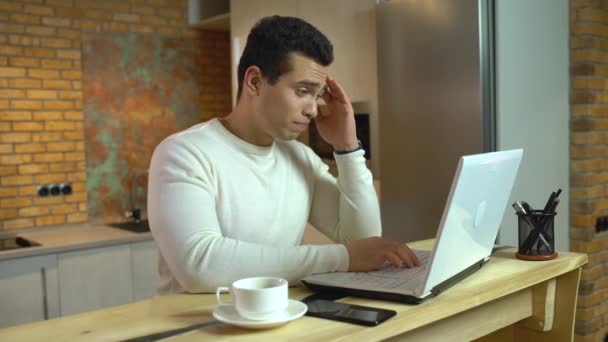 Мужчина менеджер чувствует головную боль, работа на ноутбуке на дому, здравоохранение, стресс — стоковое видео