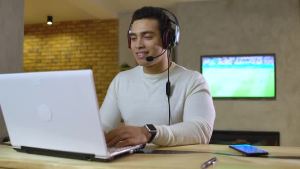 Ενθουσιασμένος αθλητικογράφος σε ακουστικά δίνοντας σχόλια για το παιχνίδι ποδοσφαίρου σε απευθείας σύνδεση, δουλειά — Αρχείο Βίντεο