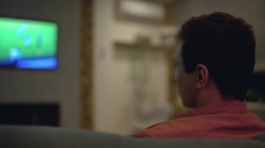 Spor taraftarı futbol maçının sonucuna üzülüyor, TV 'de maç izliyor, bahis oynuyor.