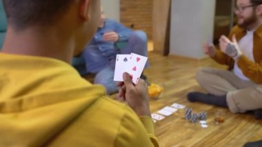 Eli zayıf olan melez bir adam, evde arkadaşlarıyla poker oynuyor, risk alıyor.