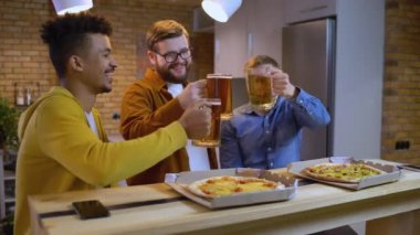 Üç mutlu arkadaş bardaklarını birayla tokuşturur, evde erkek partisi, arkadaşlık